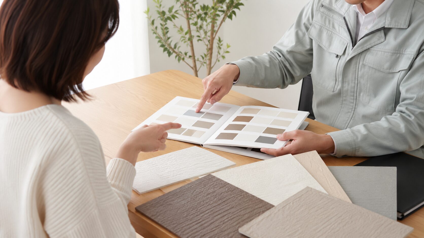 外壁塗装の色見本を見ながら相談しているイメージ画像